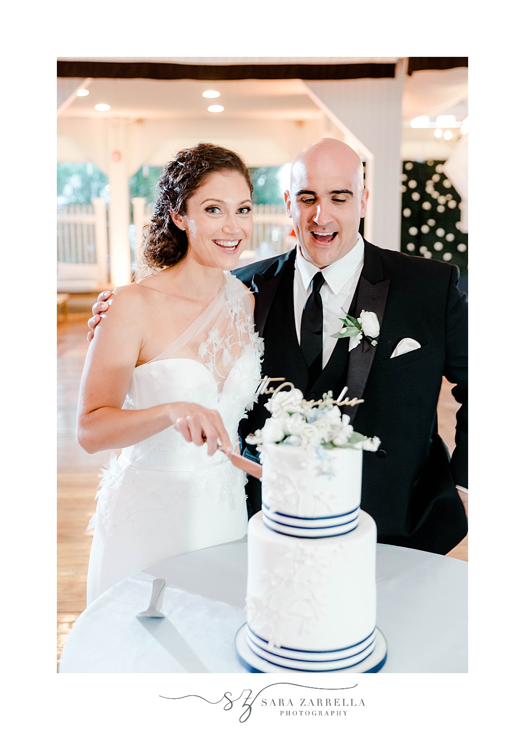 bride and groom smile by wedding cake at Regatta Place
