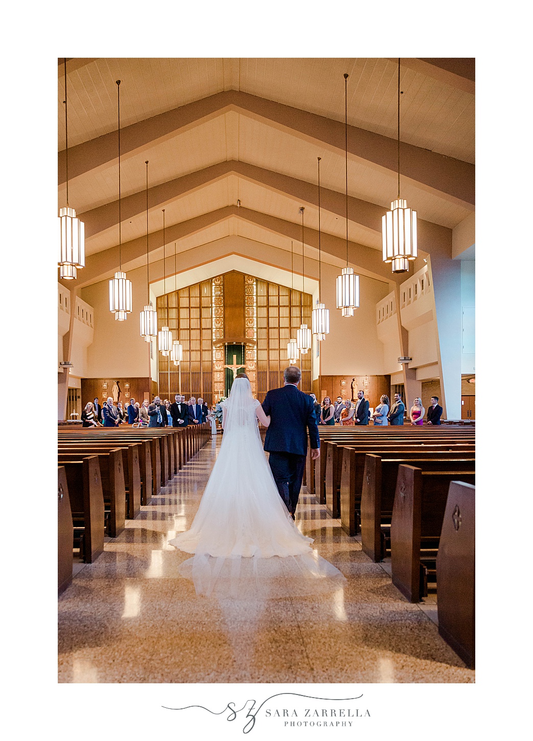 bride and father walk down aisle during traditional wedding ceremony in Rhode Island