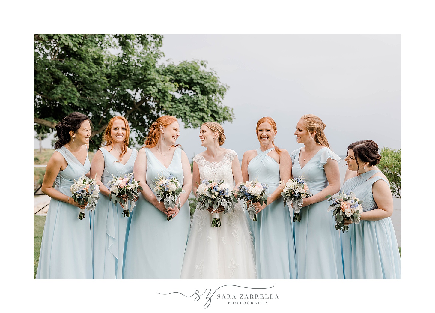 bride laughs with bridesmaids in light blue gowns at Squantum Association