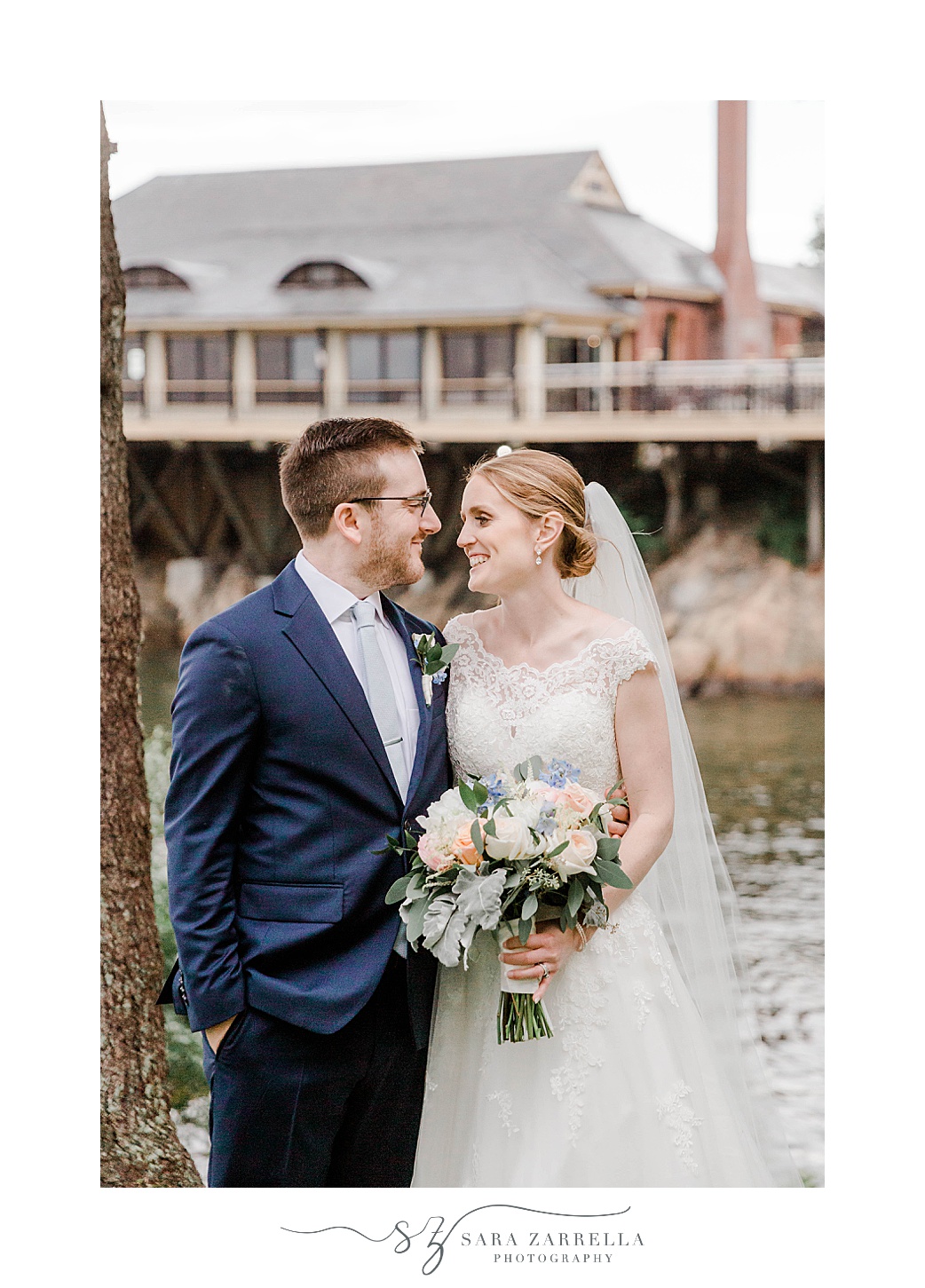 newlyweds smile together in front of Squantum Association