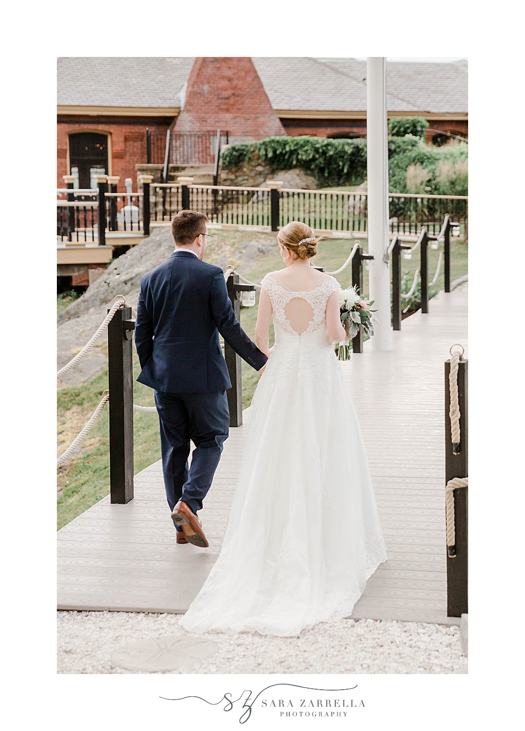 bride and groom hold hands walking down walkway at Squantum Association