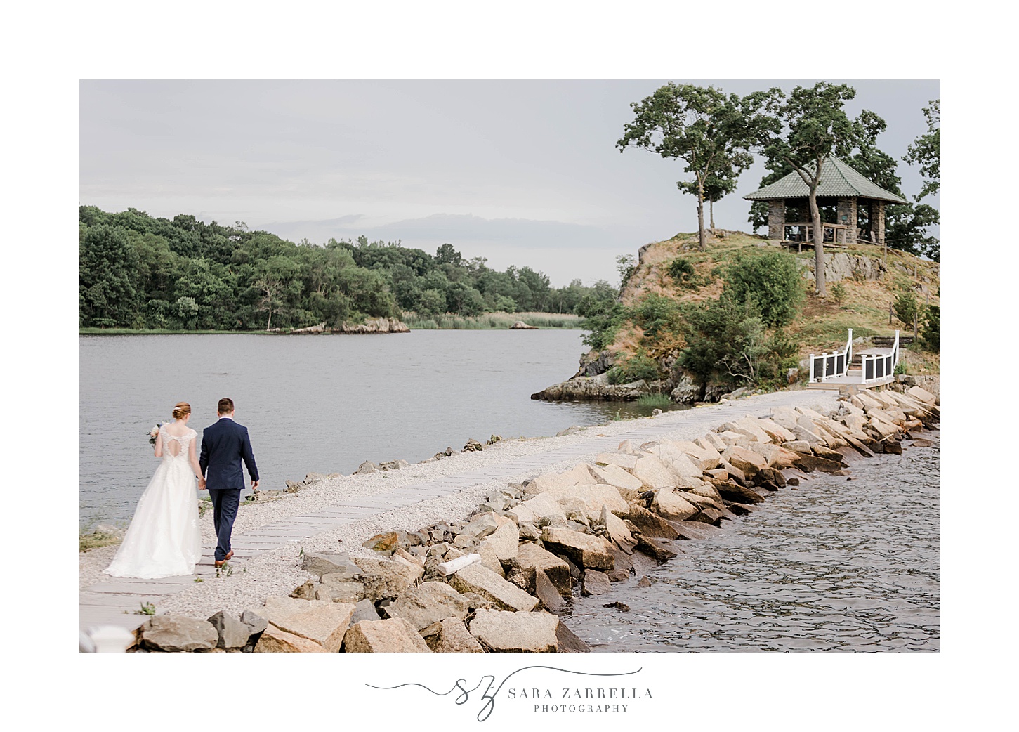 bride and groom walk over stone walkway outside Squantum Association