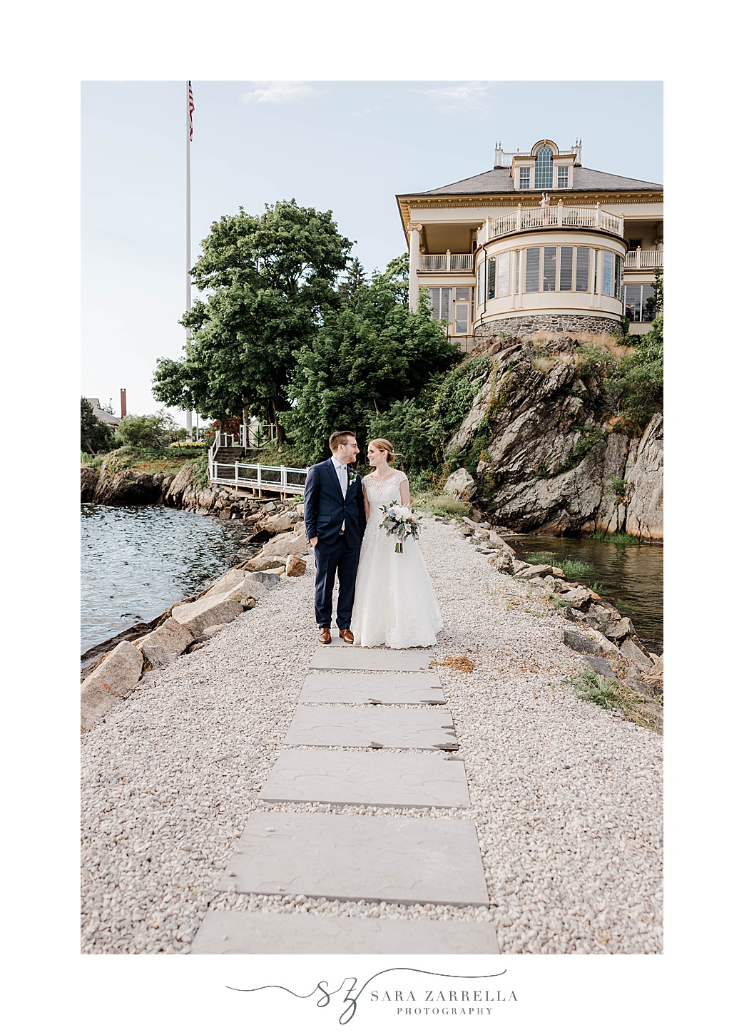 bride and groom walk over beach walkway at Squantum Association