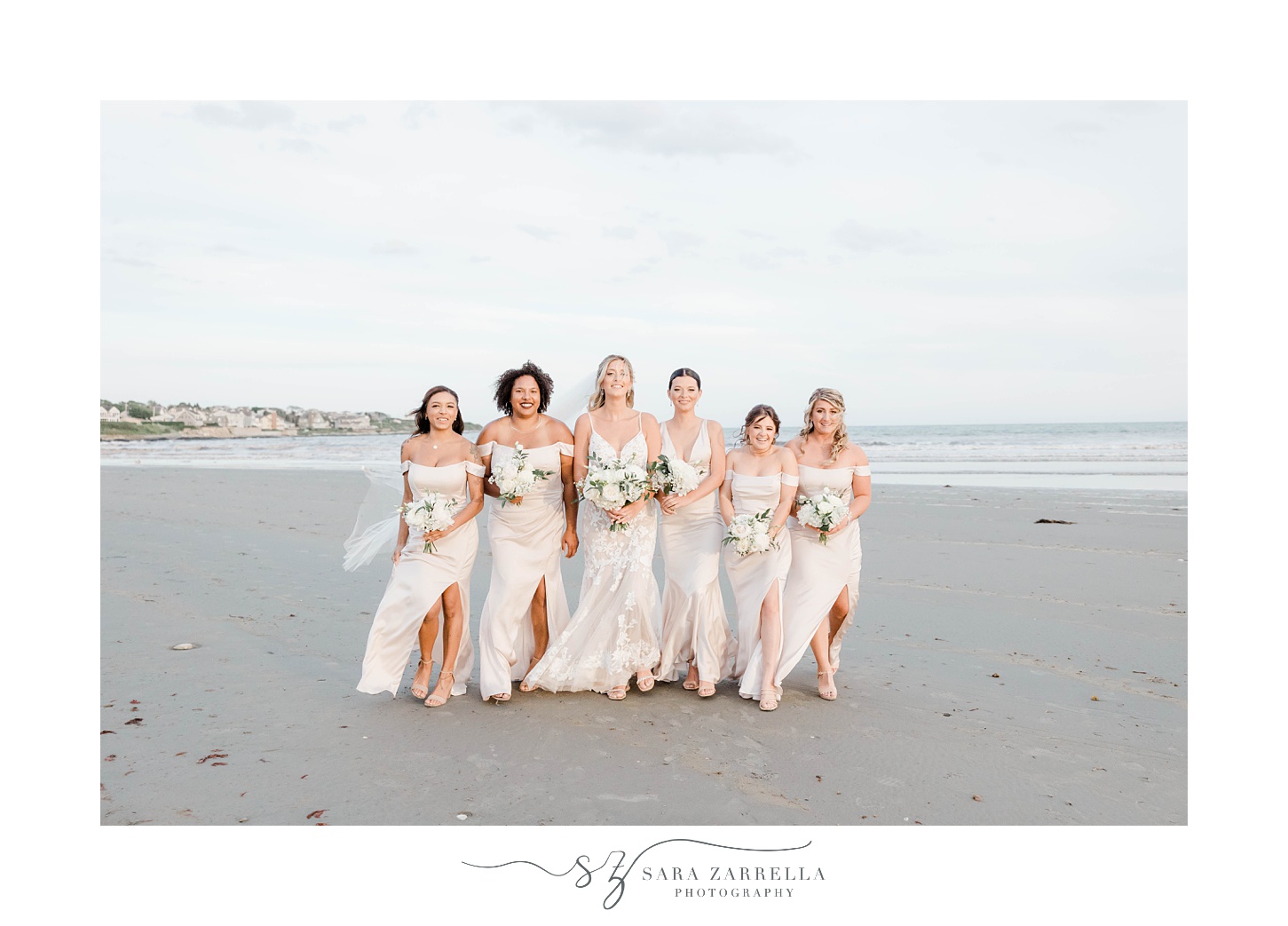 bride walks on beach with bridesmaids in paste pink gowns