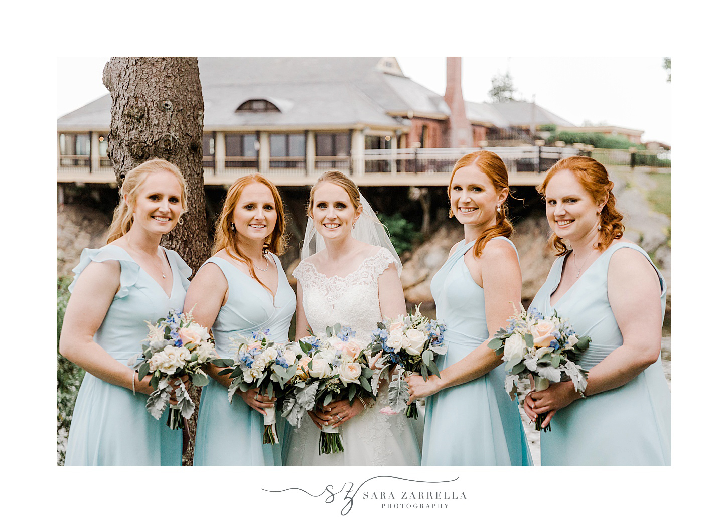 bride and bridesmaids stand holding pastel bouquets outside Squantum Association