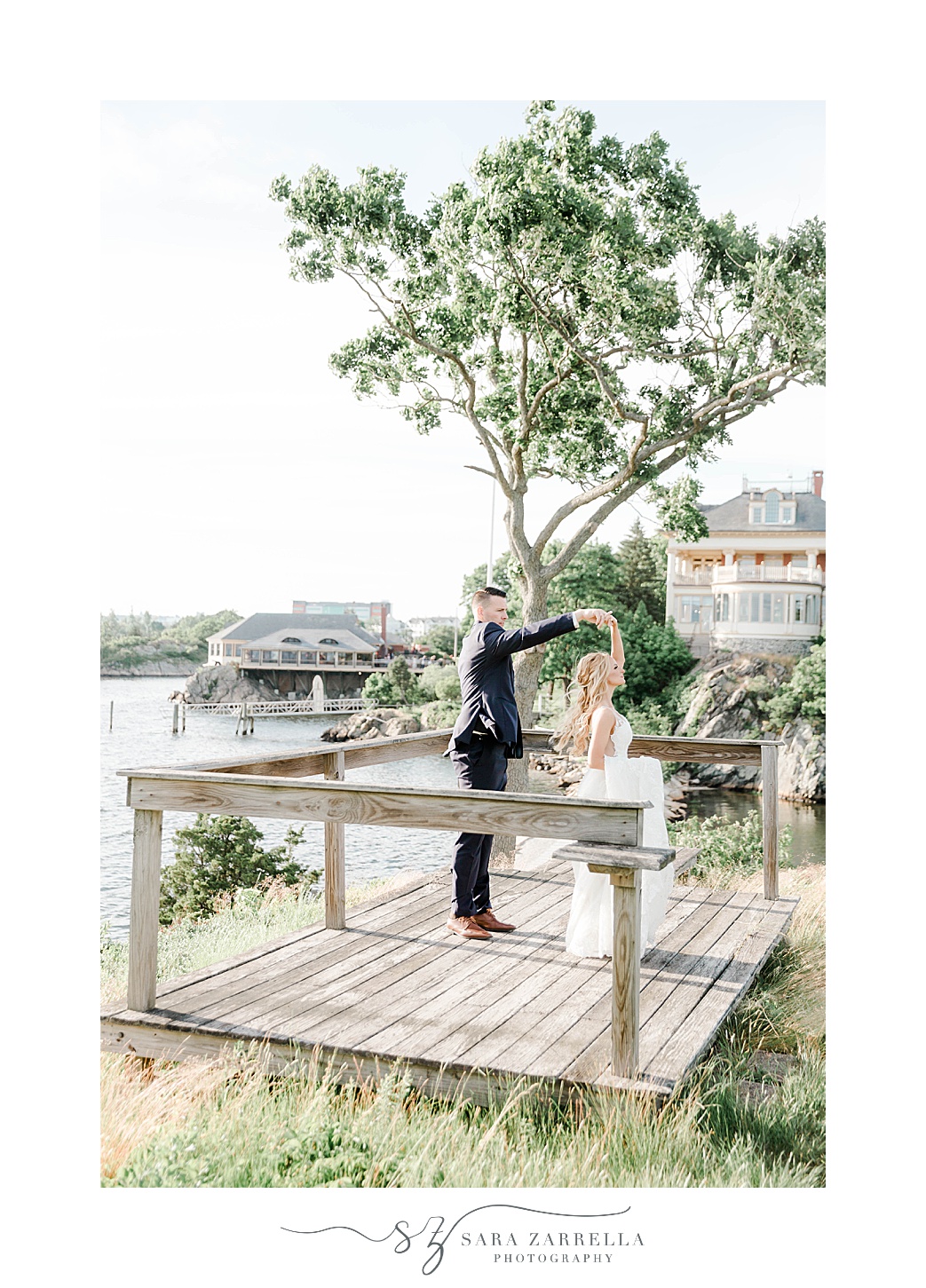 groom twirls bride on wooden dock at Squantum Association