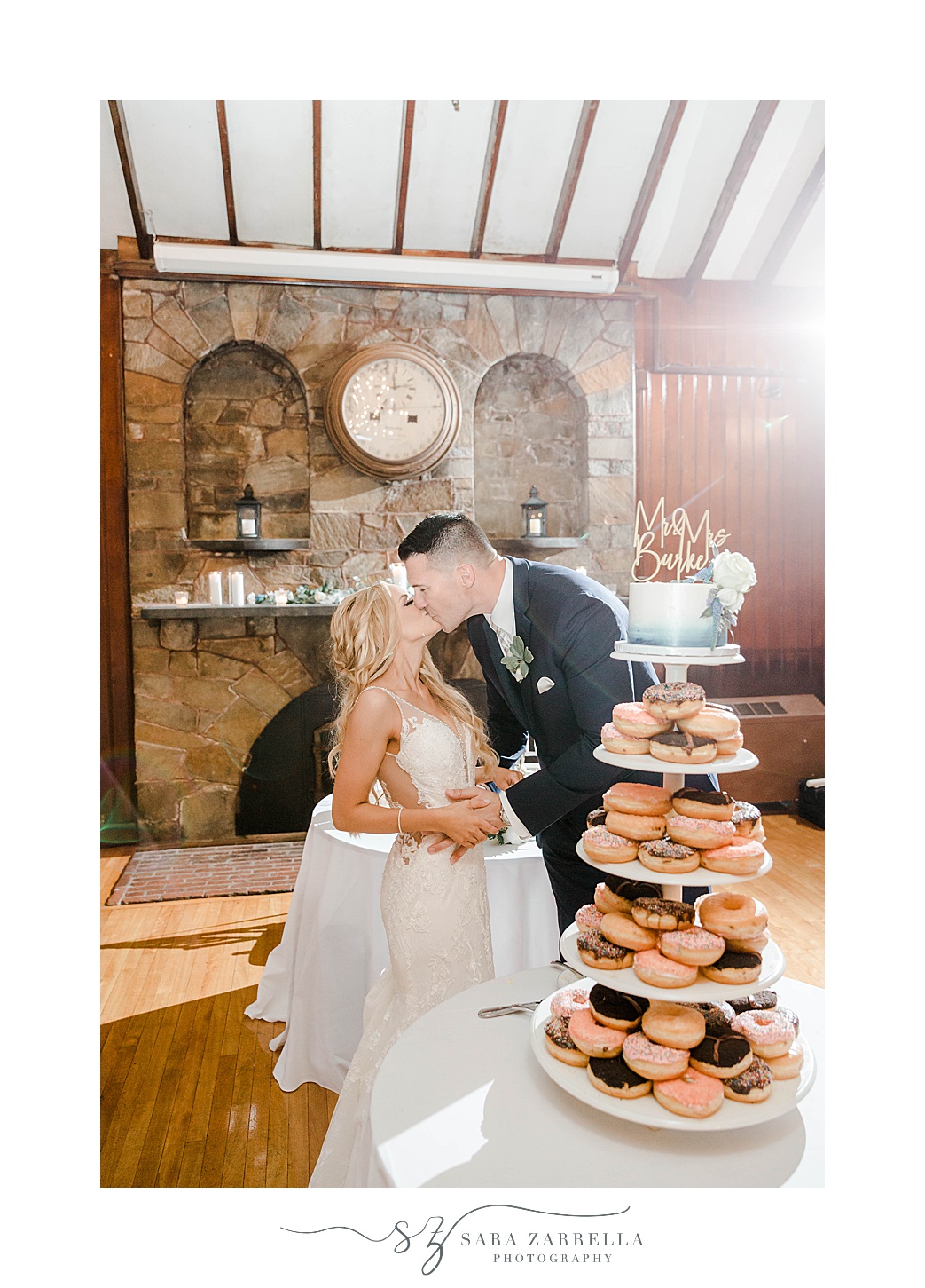 bride and groom kiss by cake and donut display at Squantum Association