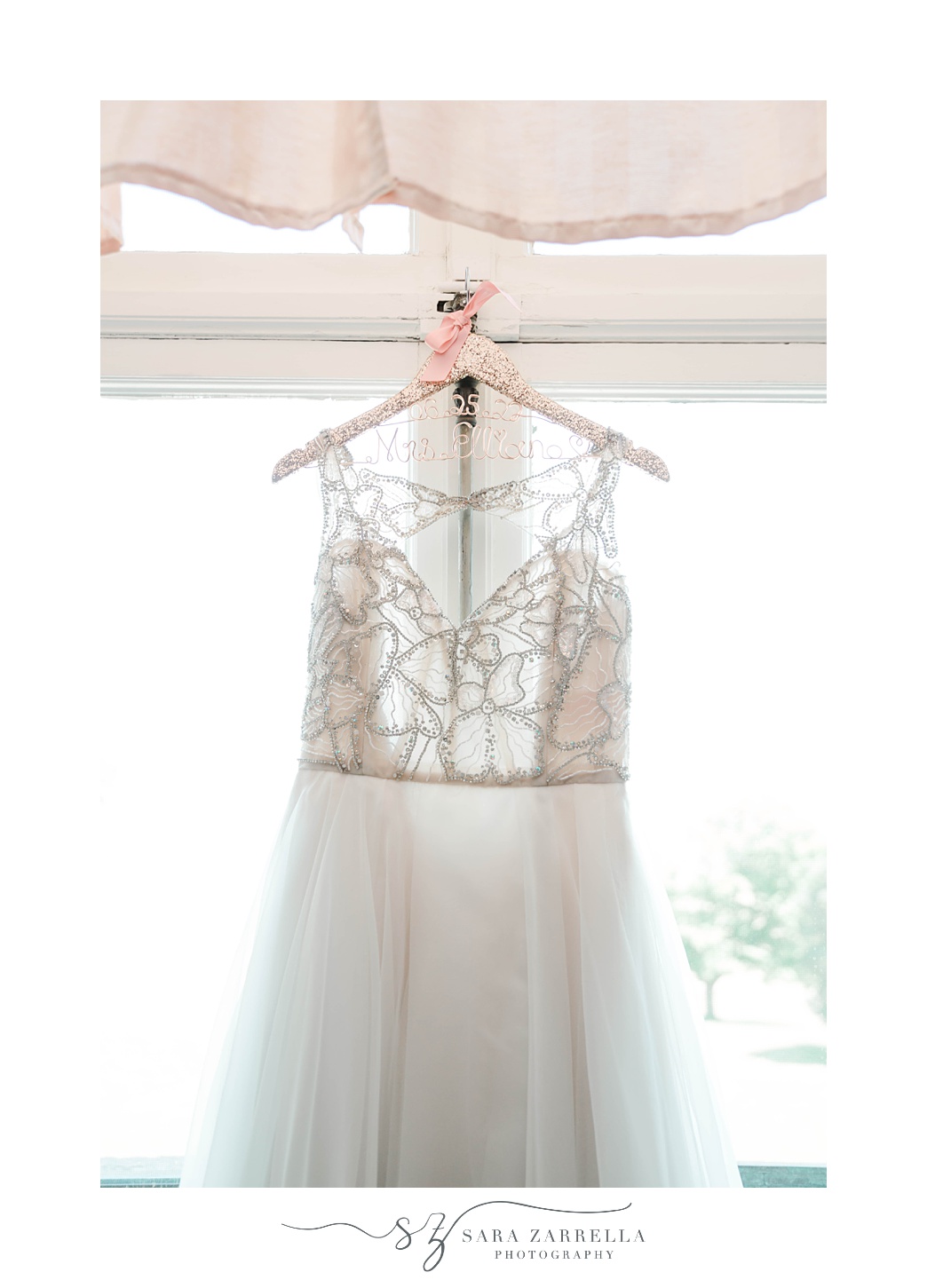 bride's dress hangs in window before Aldrich Mansion wedding