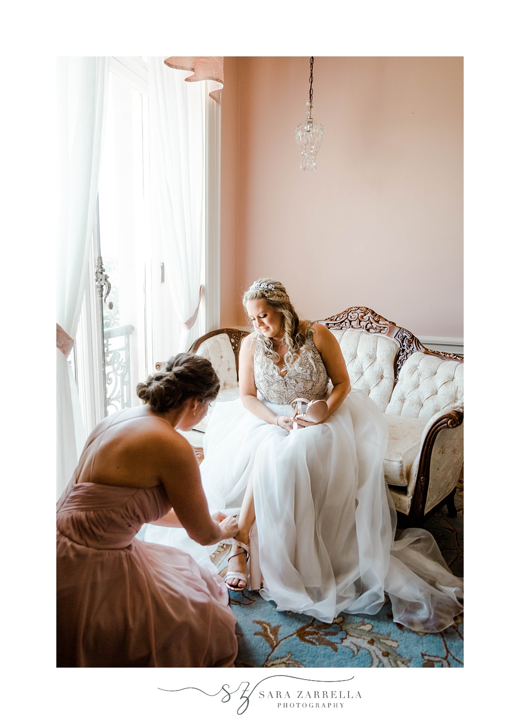 bridesmaid helps bride with shoes in bridal suite at Aldrich Mansion 