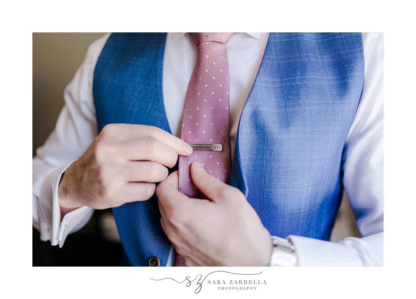 groom puts on tie clip before Aldrich Mansion wedding