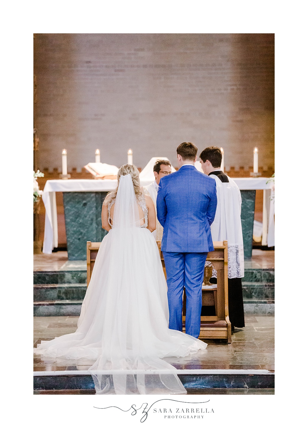 bride and groom kneel at alter during traditional wedding ceremony in church
