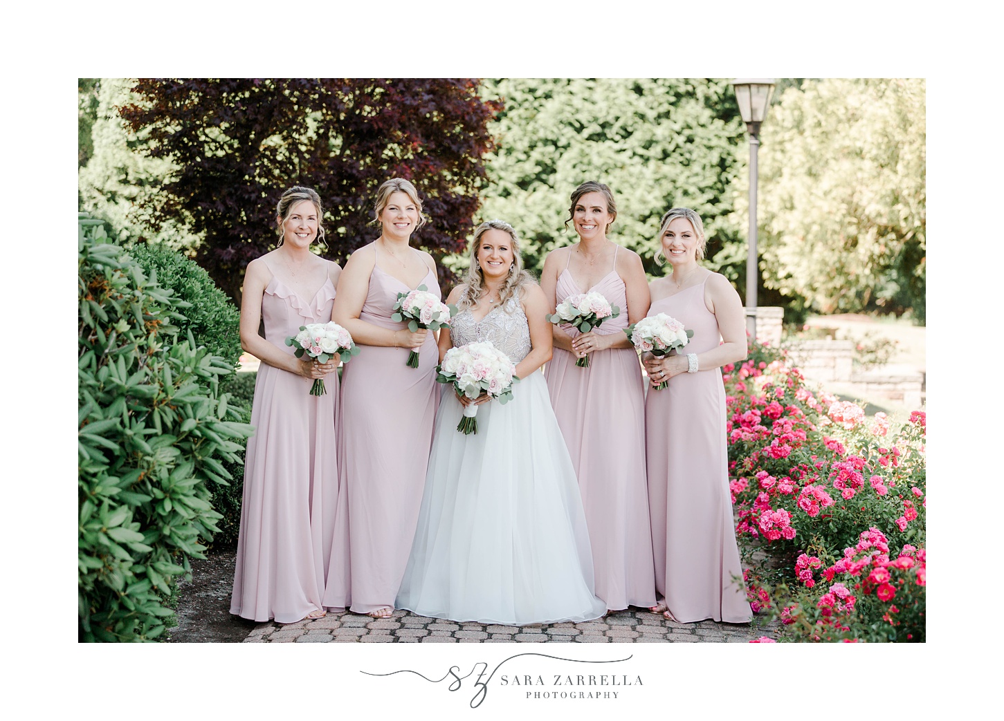 bride stands with bridesmaids in pink dresses at Aldrich Mansion