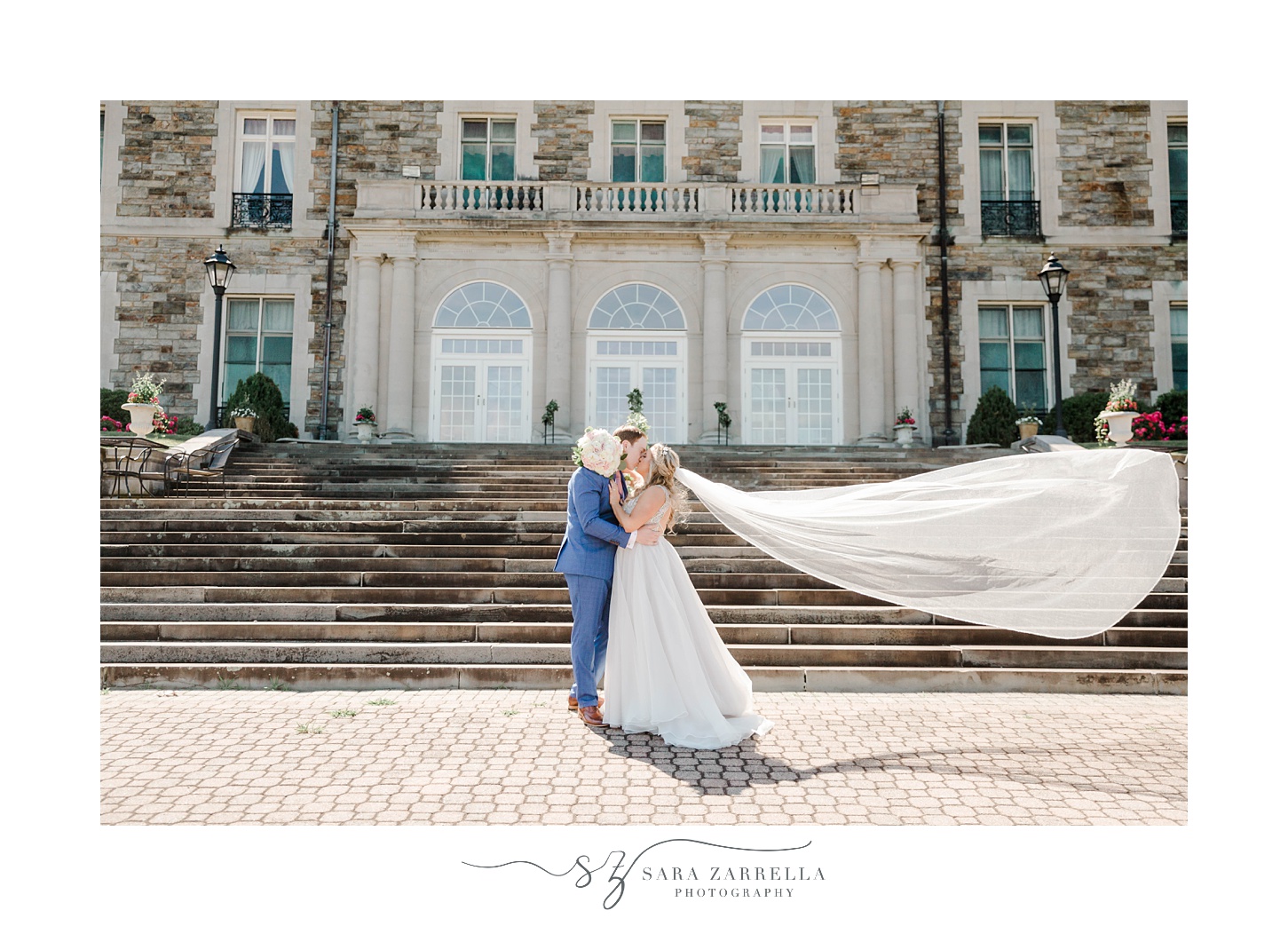 bride and groom kiss with bride's veil floating outside Aldrich Mansion