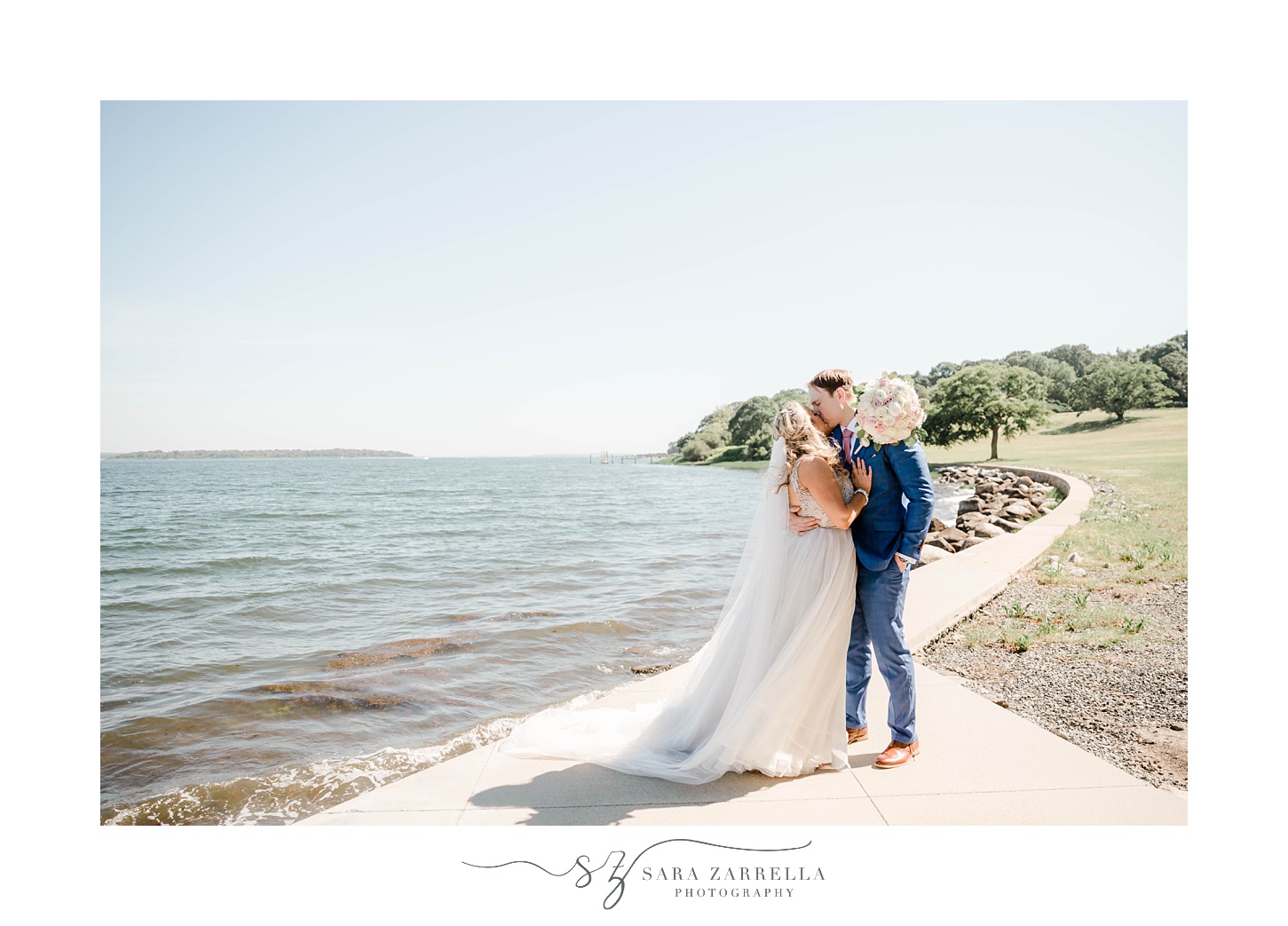 newlyweds stand on walkway along Narragansett Bay in Warwick RI