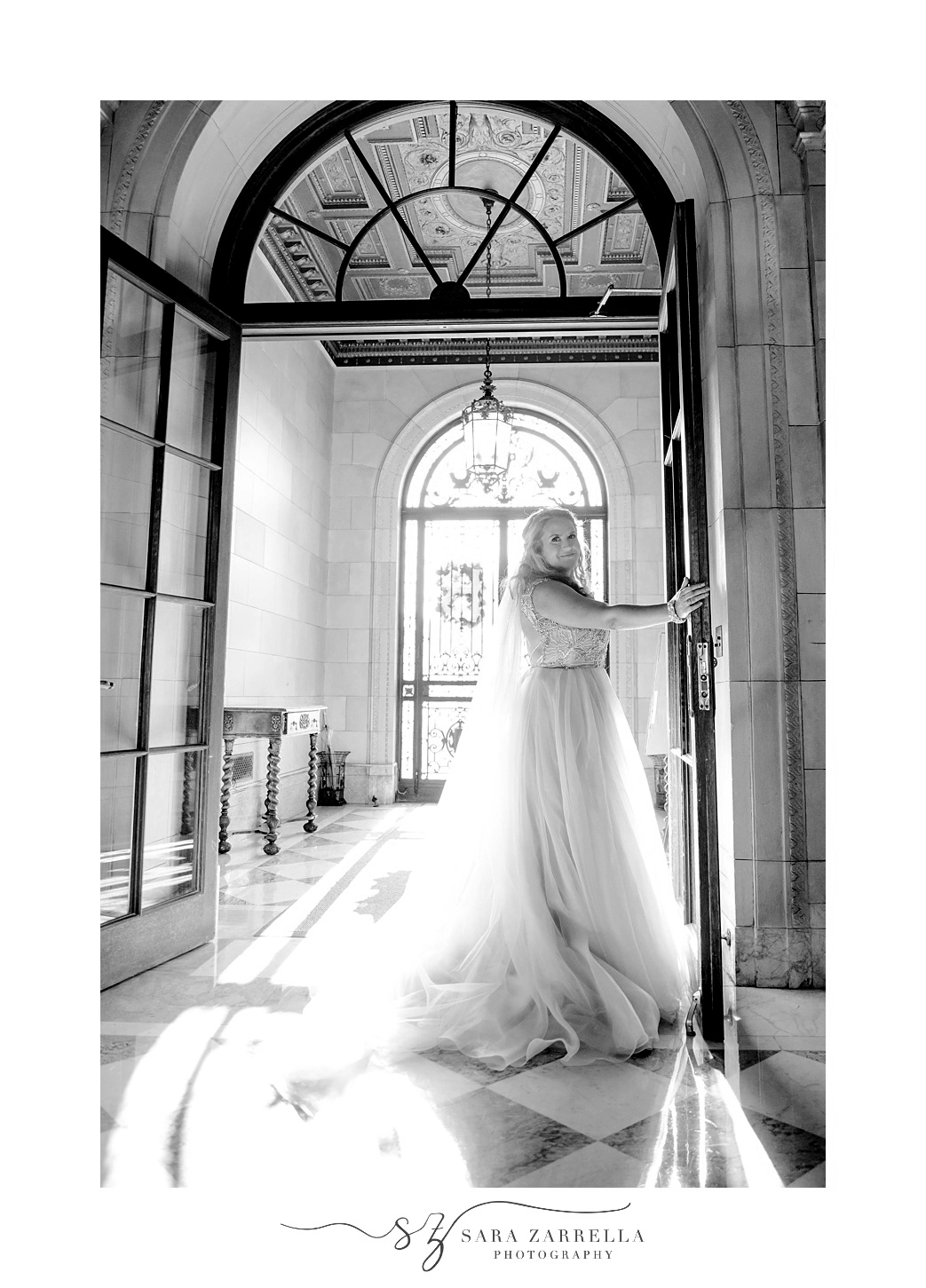 bride stands looking over shoulder during portraits in doorway at Aldrich Mansion