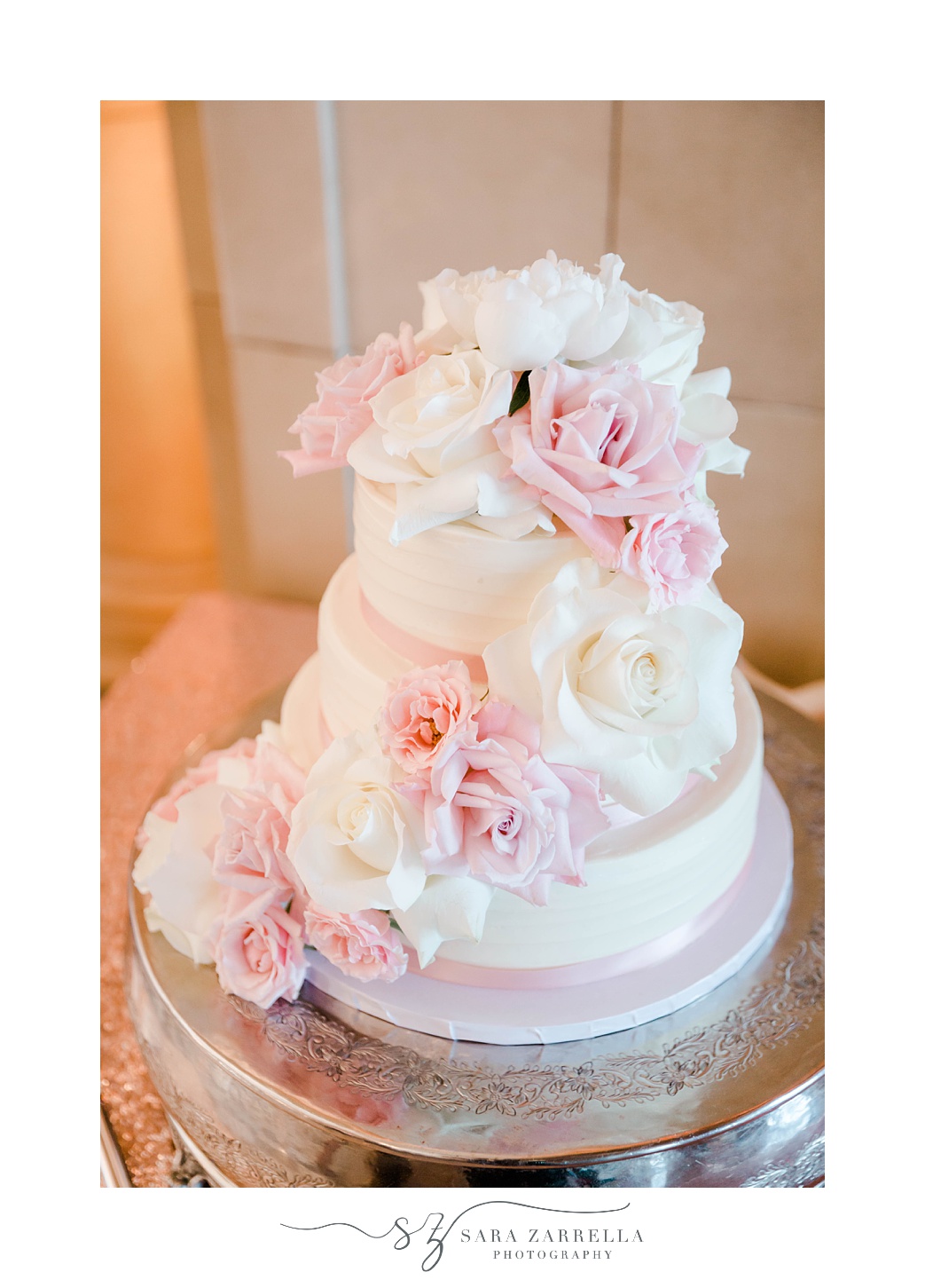 tiered wedding cake with pink and ivory flowers