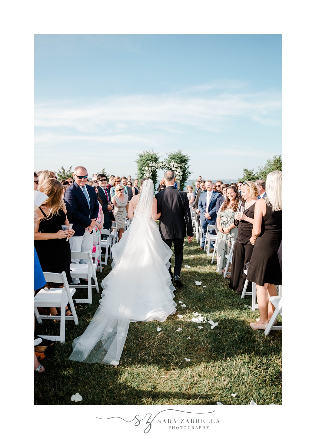bride walks down aisle with father at Castle Hill Inn wedding