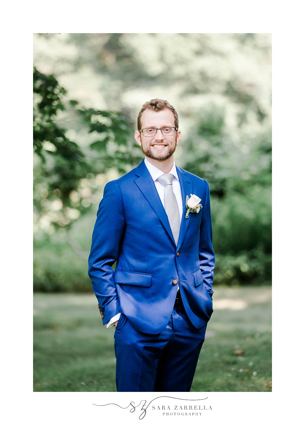 groom stands in bright blue jacket at Castle Hill Inn