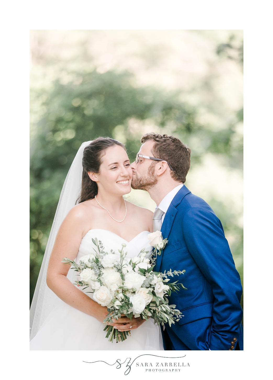 groom leans to kiss bride's cheek during RI wedding photos at Castle Hill Inn