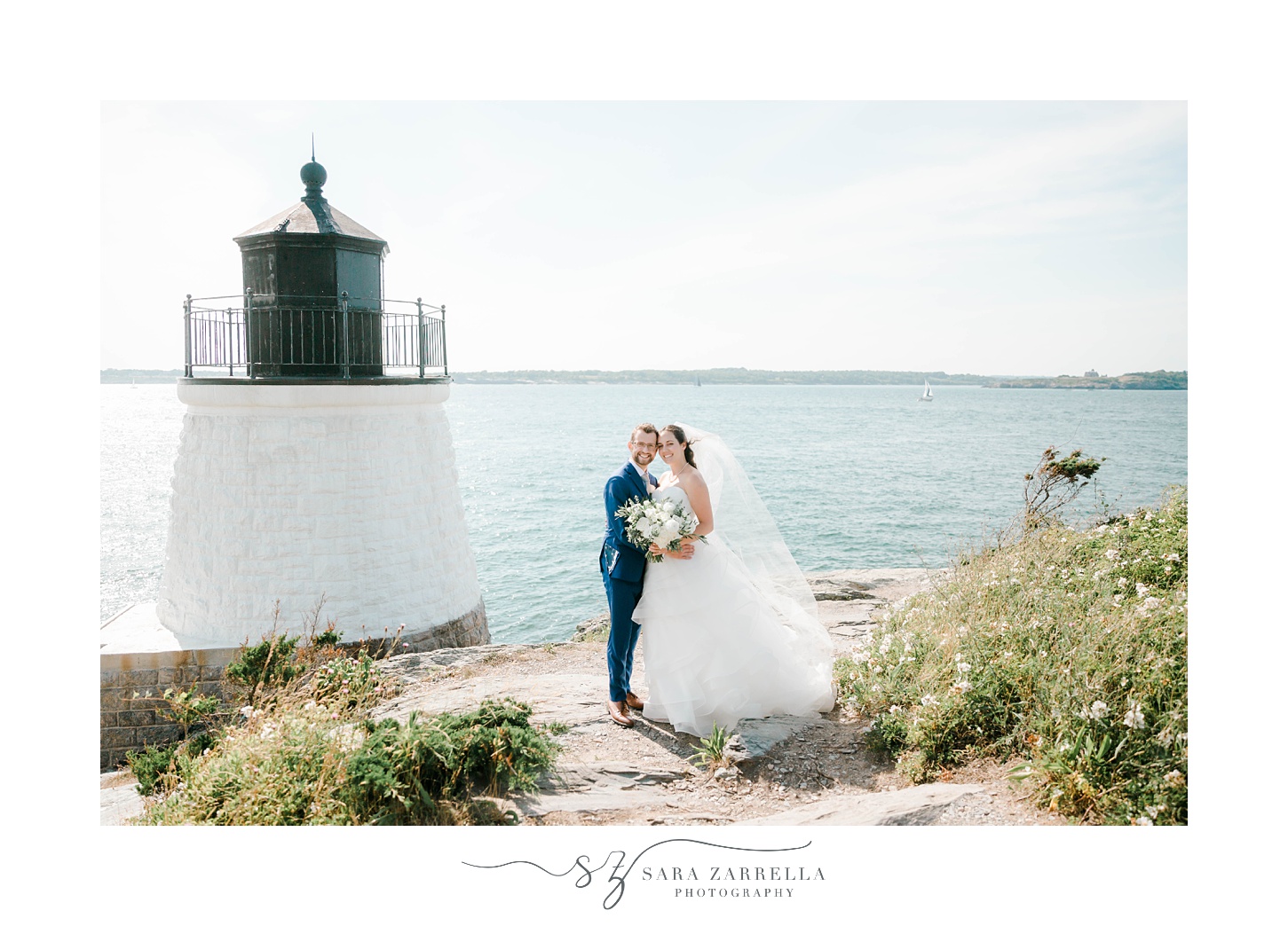 newlyweds lean heads together during portraits by lighthouse
