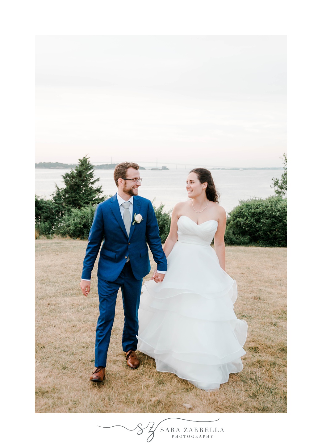 bride and groom hold hands walking at Castle Hill Inn