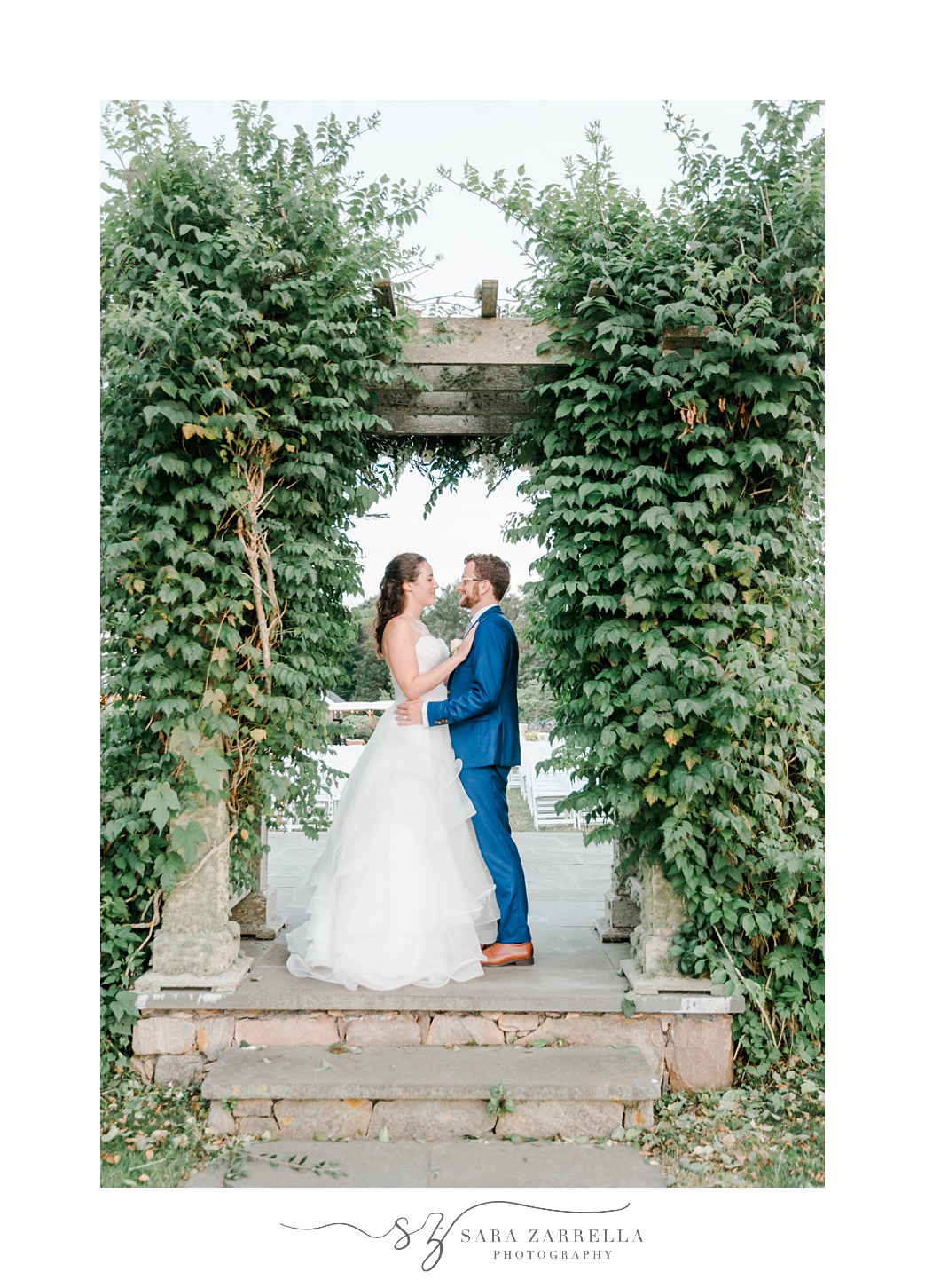 bride and groom hug in ivy covered alter at Castle Hill Inn