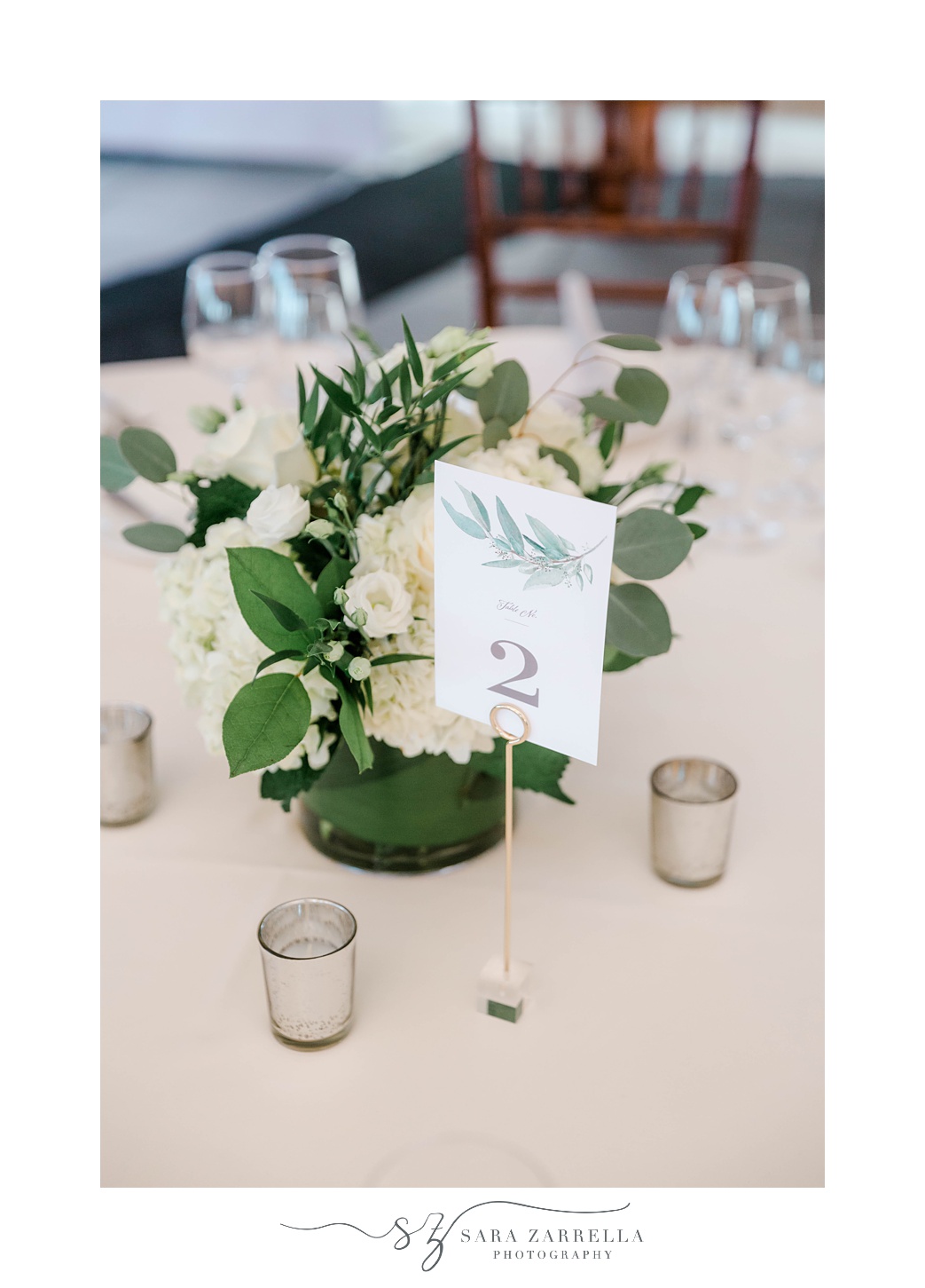 centerpieces with simple green flowers and table numbers 
