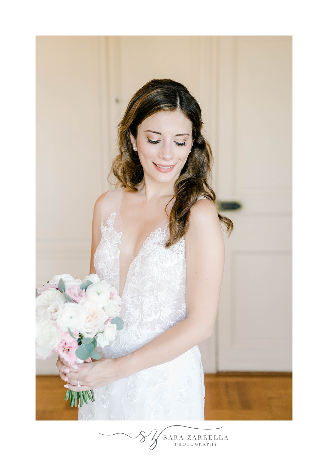 bride stands holding pastel bouquet looking over shoulder