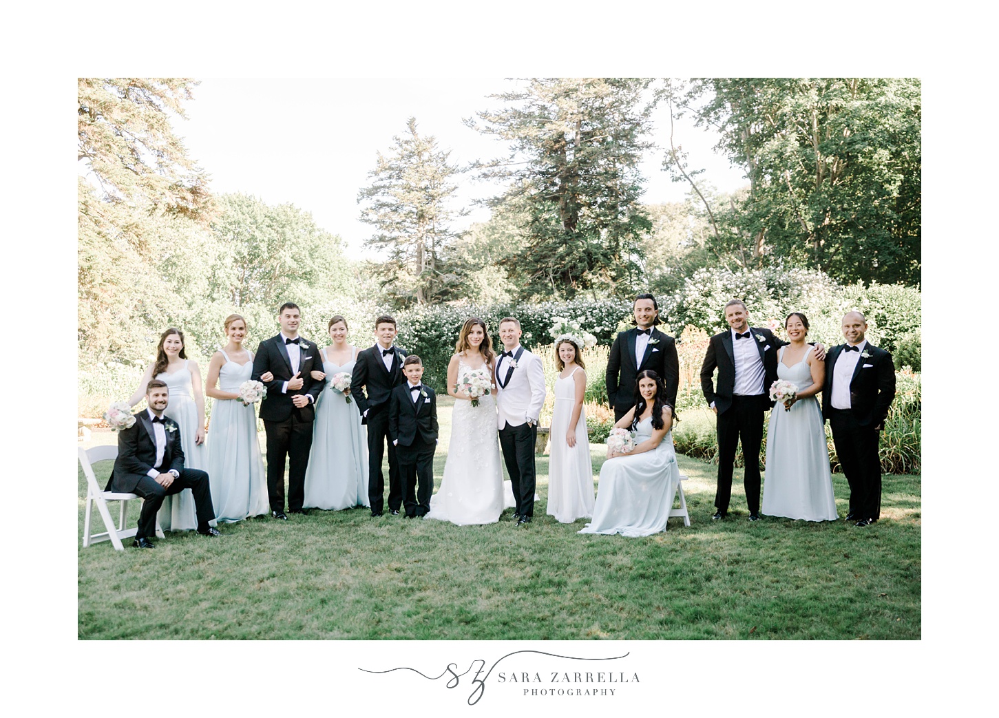 bride and groom smile with wedding party on lawn at Glen Manor House