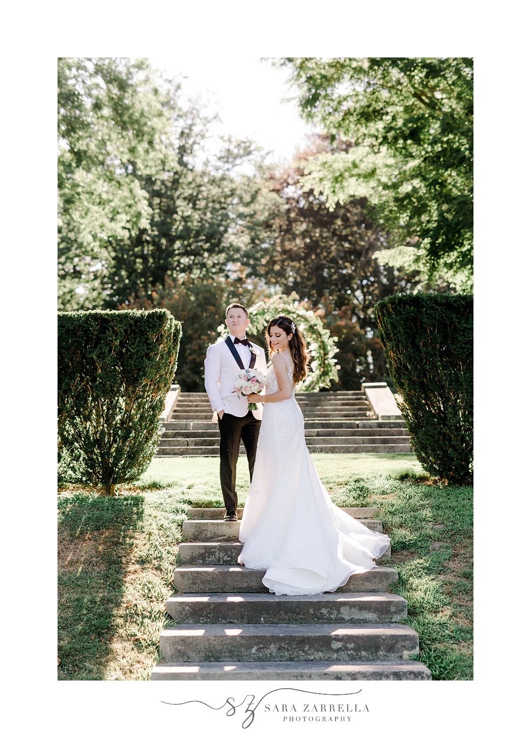 bride and groom stand on stone steps
