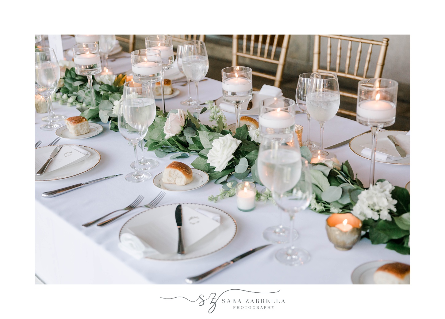 table setting with greenery runner and gold and white plates