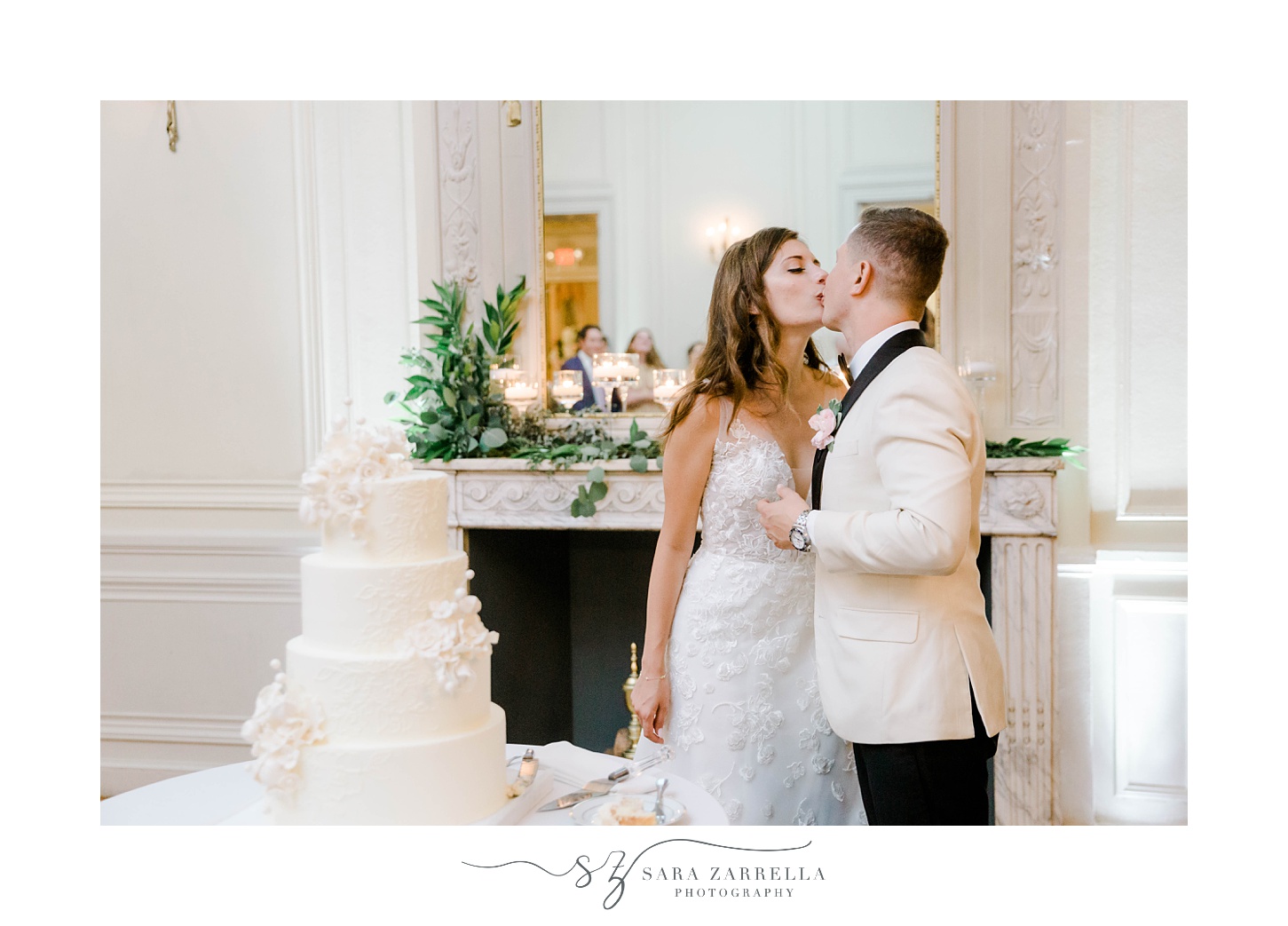 bride and groom kiss by cake during Portsmouth RI wedding reception