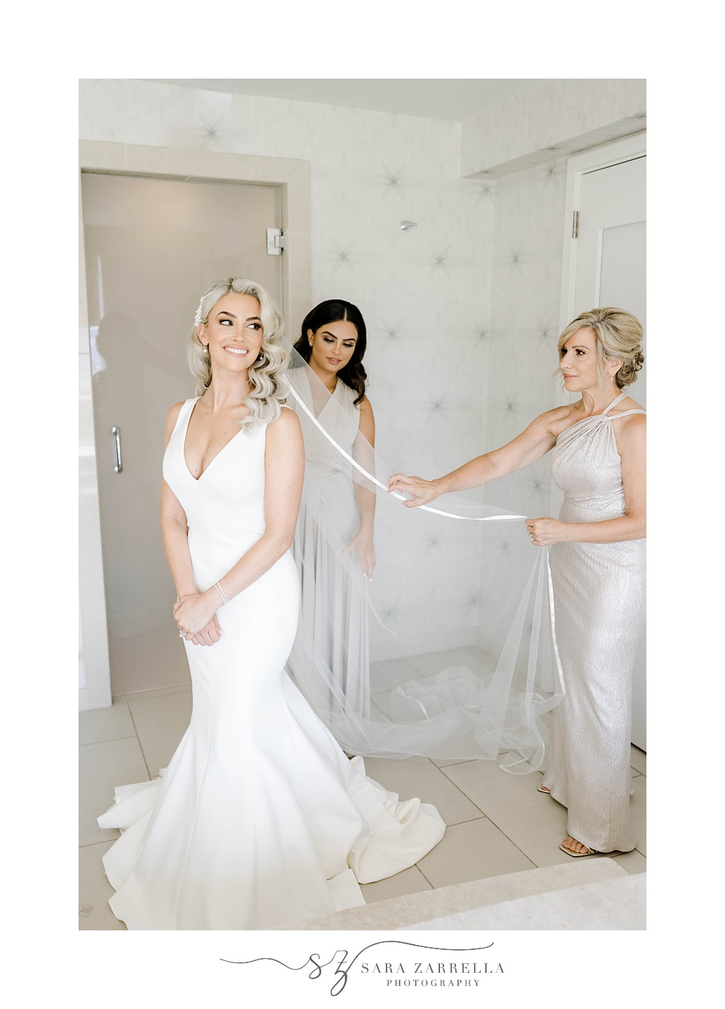 bridesmaid and mom help bride with veil at Gurney’s Newport Resort