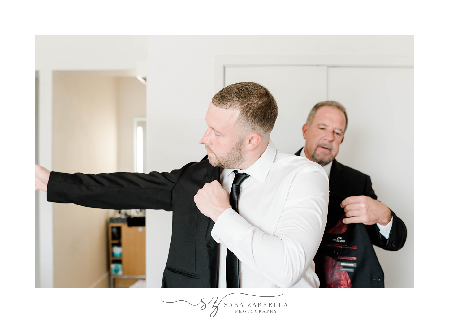 father helps groom into jacket before Gurney’s Newport Resort wedding