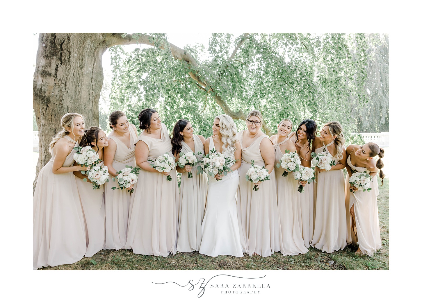 bride and bridesmaids laugh together standing under tree at The Elms