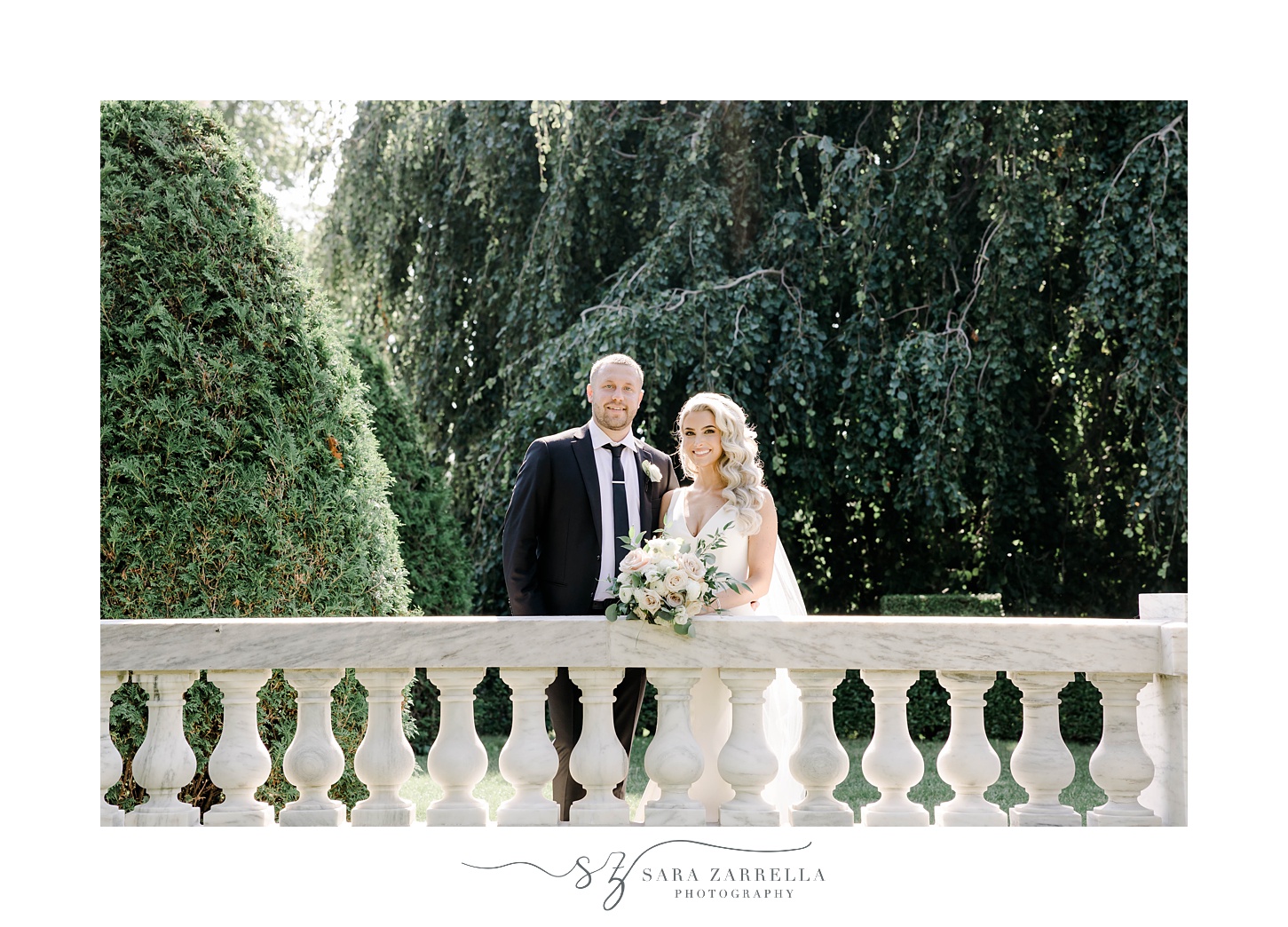 newlyweds stand by stone railing at The Elms