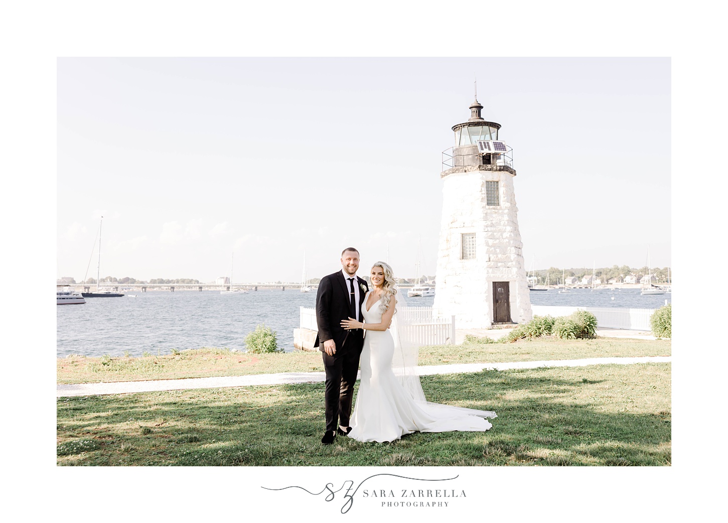 newlyweds pose by Newport lighthouse during photos in Rhode Island