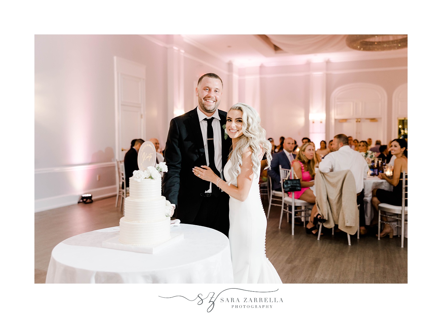 newlyweds pose with wedding cake at Gurney's Newport Resort