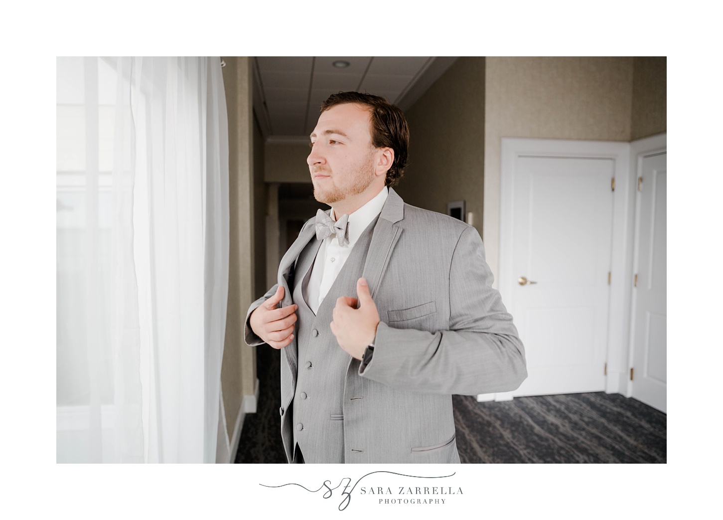 groom pulls on grey suit jacket 