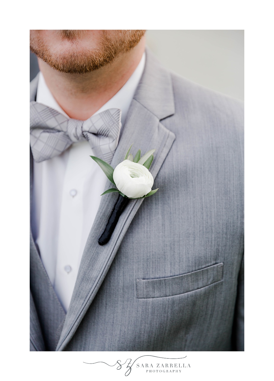 groom's grey jacket and simple white boutonniere 