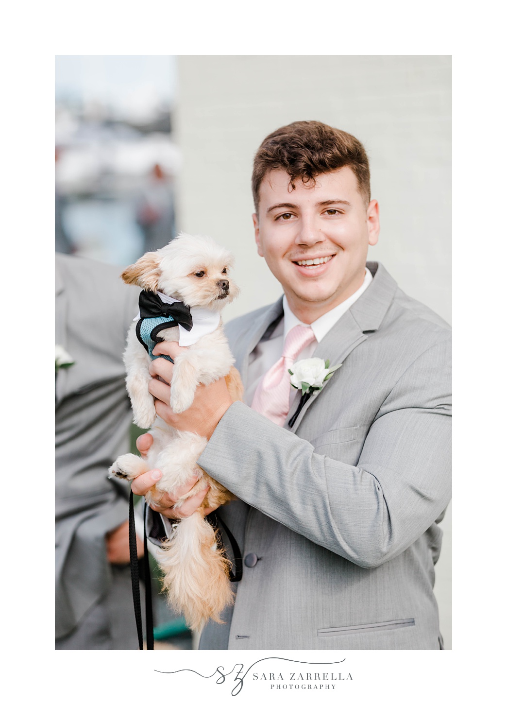 groomsman poses with dog at Gurney’s Newport