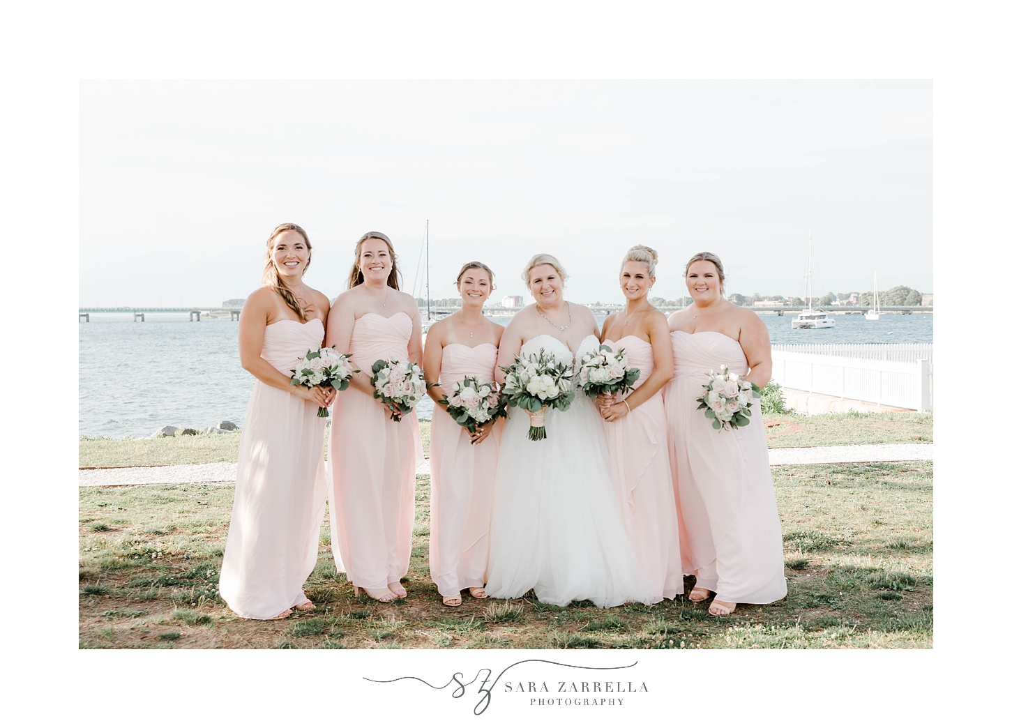 bride stands with four bridesmaids in pink gowns
