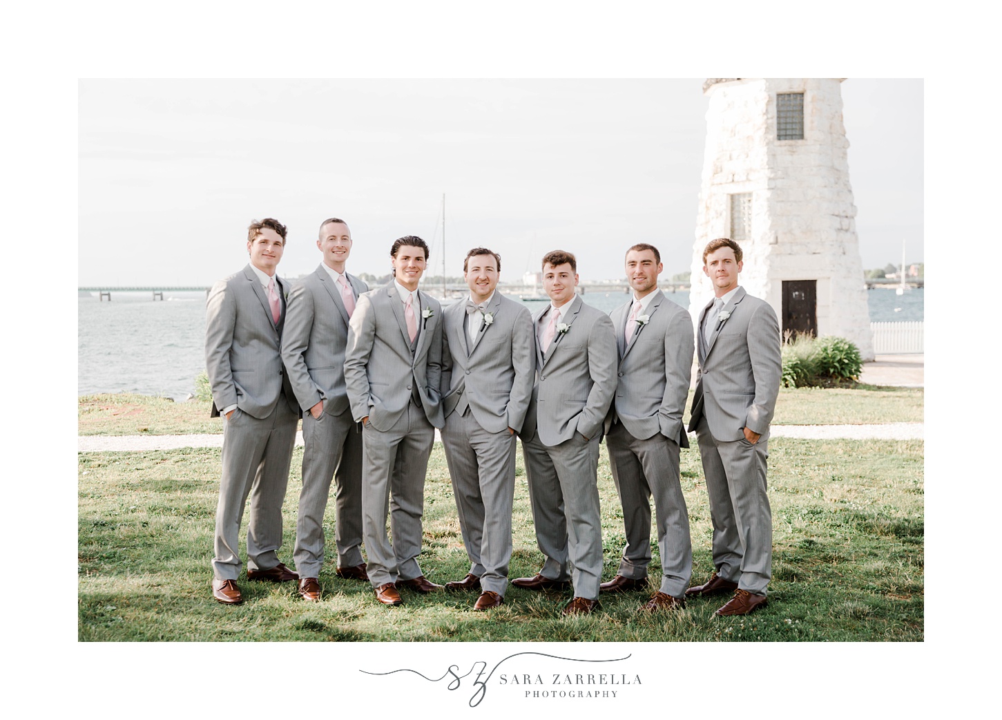 groom stands with groomsmen in grey suits