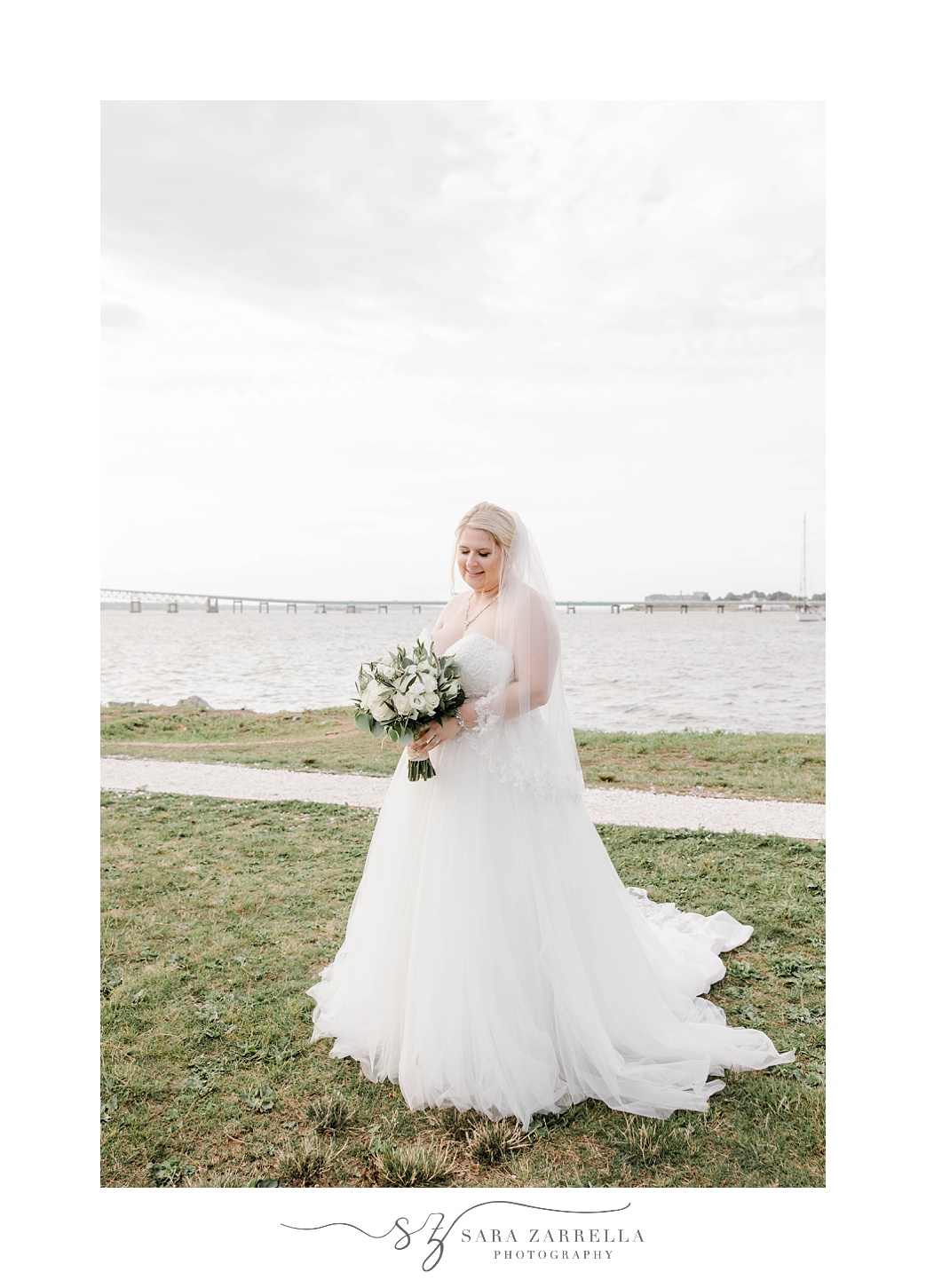 bride poses alongside bay in Newport RI