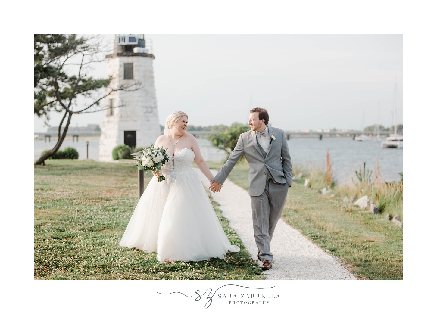 bride and groom hold hands walking near lighthouse at Gurney’s Newport Resort