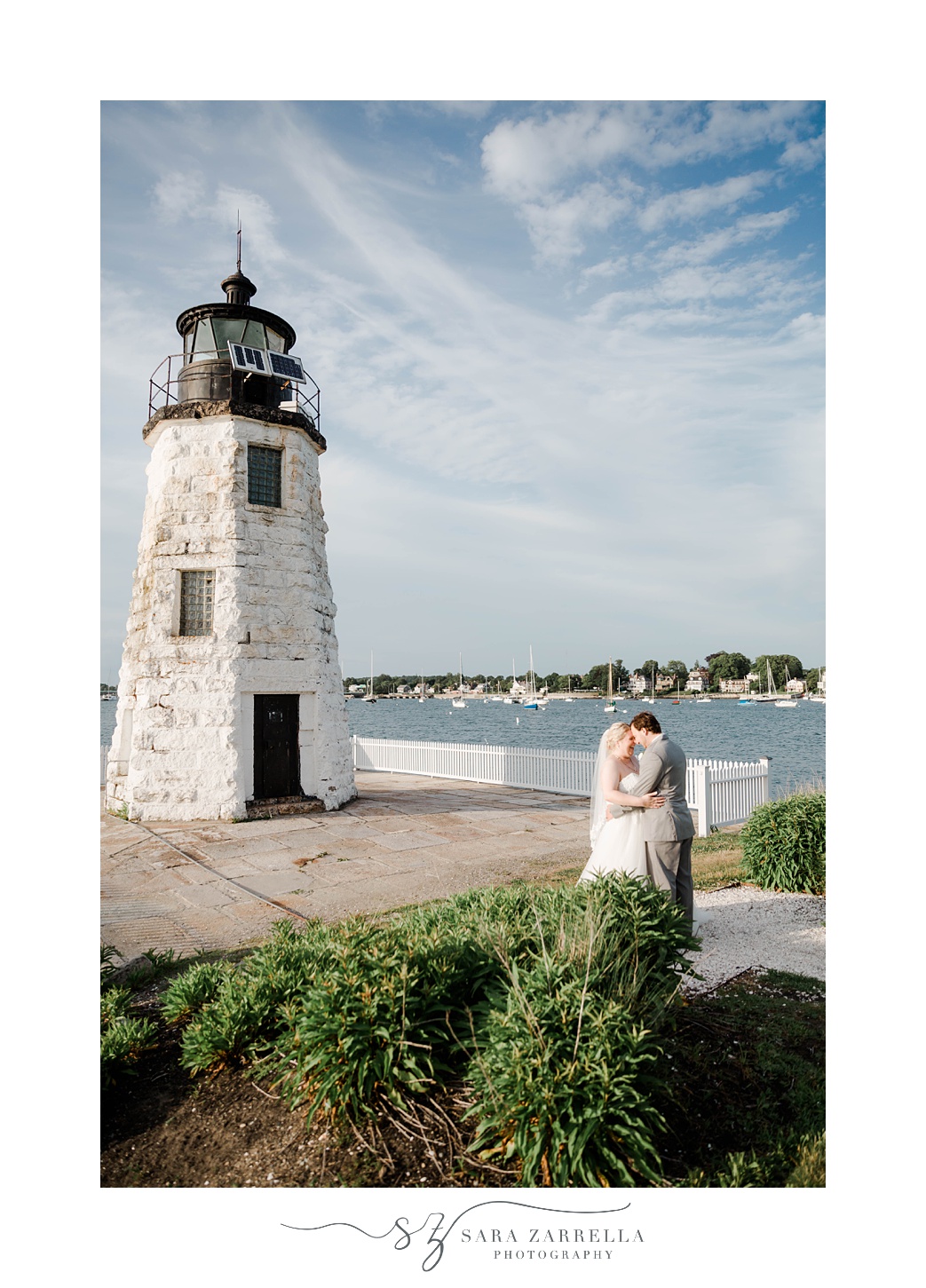 bride and groom stand by Newport RI lighthouse