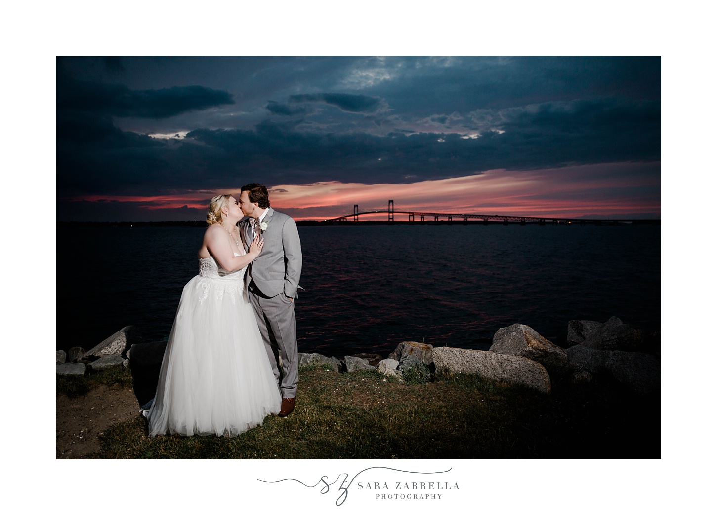 bride and groom kiss on rocks in Newport RI at sunset