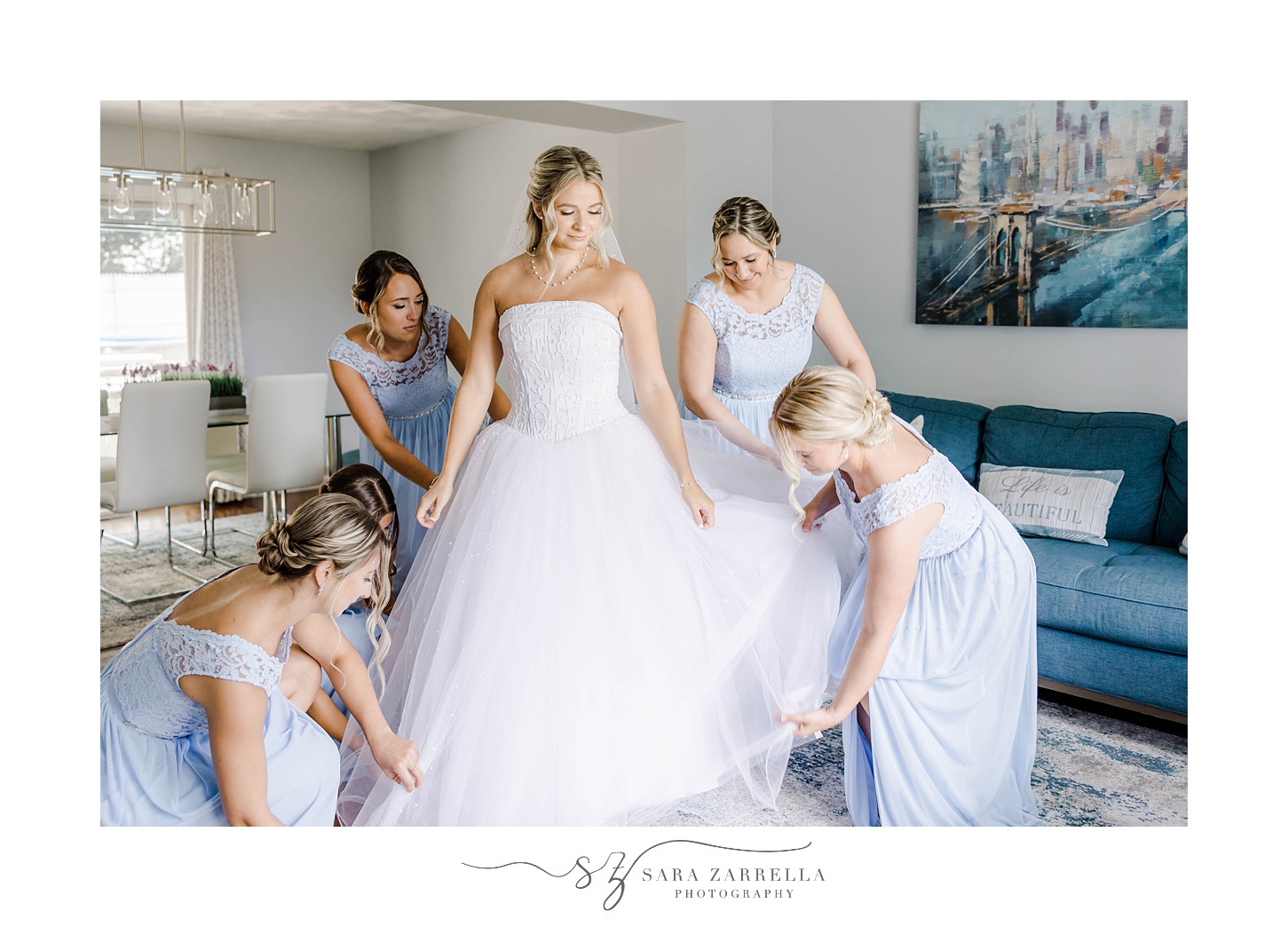 bridesmaids help bride with wedding dress