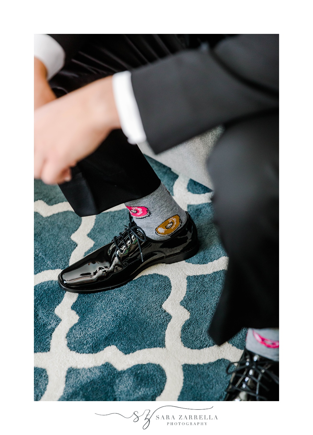 groom sits on couch showing off donut socks