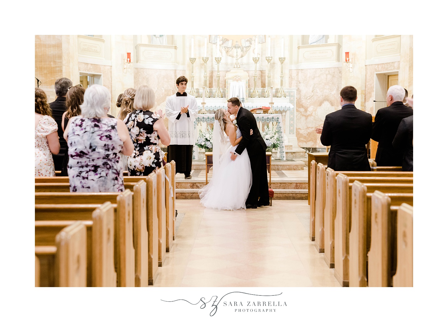bride and groom kiss during Catholic church wedding ceremony in Rhode Island